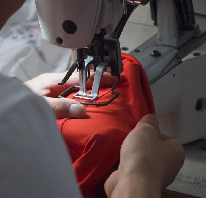 Skillful Sewing Worker Proceeding Double Stitching On Custom Hoodies To Meet Quality Requirements